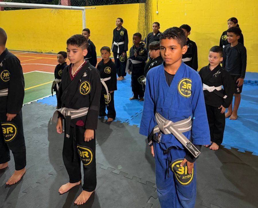 Alunos de quimono na aula de jiu-jitsu do PERES+, na quadra da escola